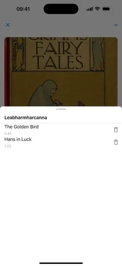 Liosta na leabharmharcanna i seinnteoir closleabhar Fablum ar iPhone: dhá leabharmharc ainmnithe de réir caibidle, „The Golden Bird” ag 0:41 agus „Hans in Luck” ag 1:23, cnaipe scriosta ag gach ceann